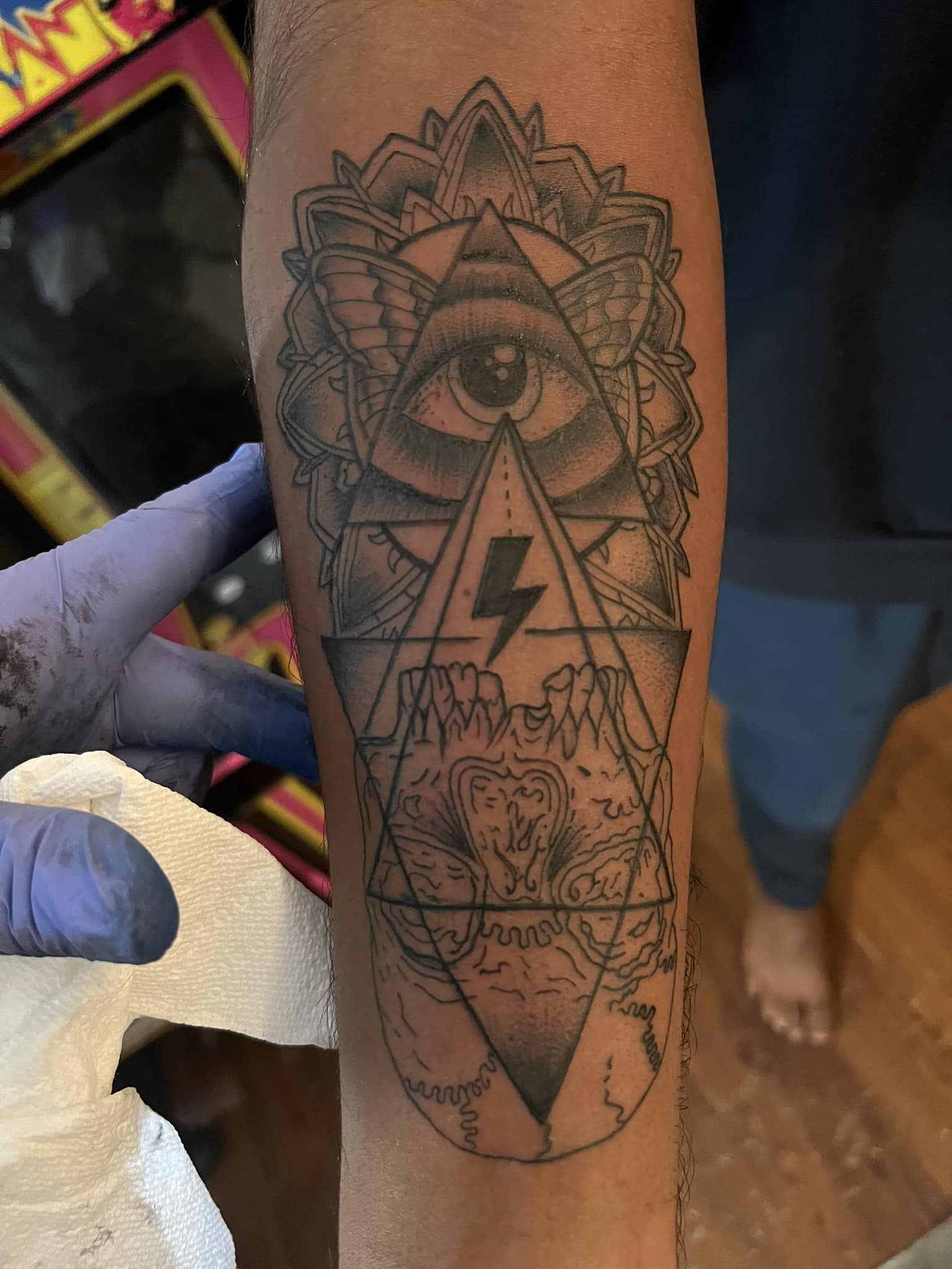 Geometric eye and skull forearm tattoo