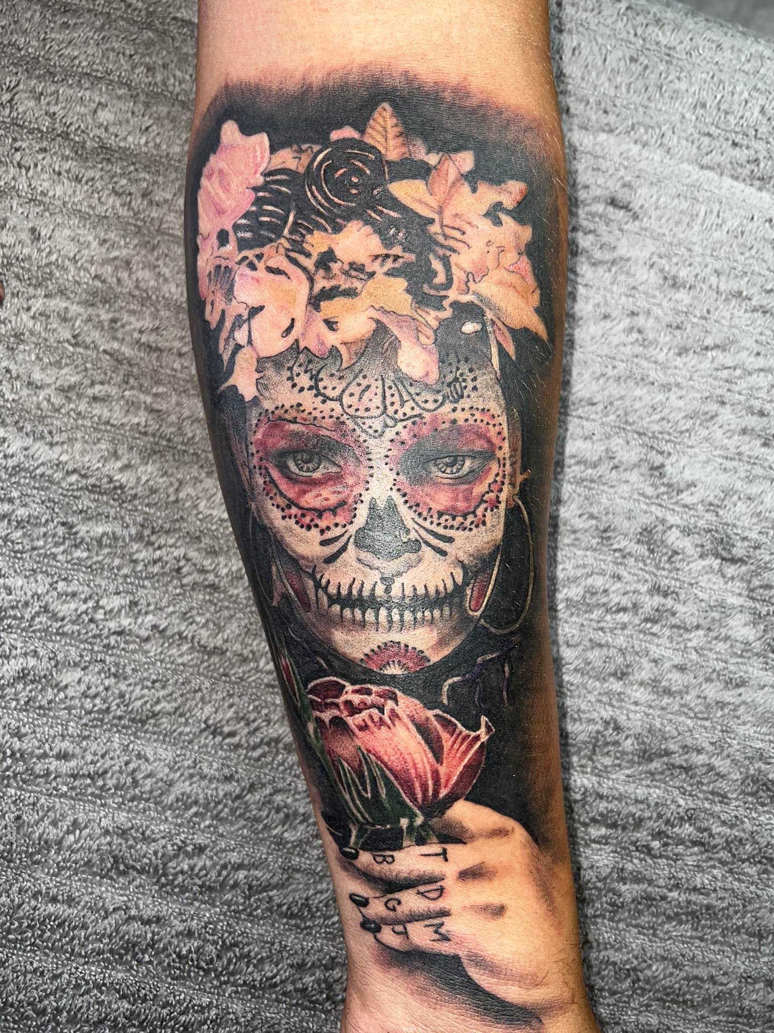 Sugar skull face with flowers and rose arm tattoo