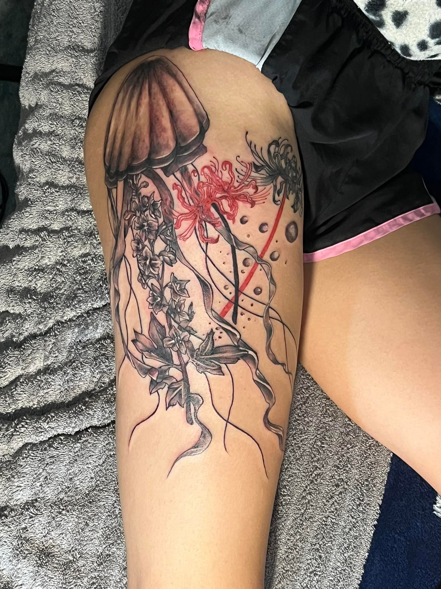 Jellyfish and spider lily thigh tattoo