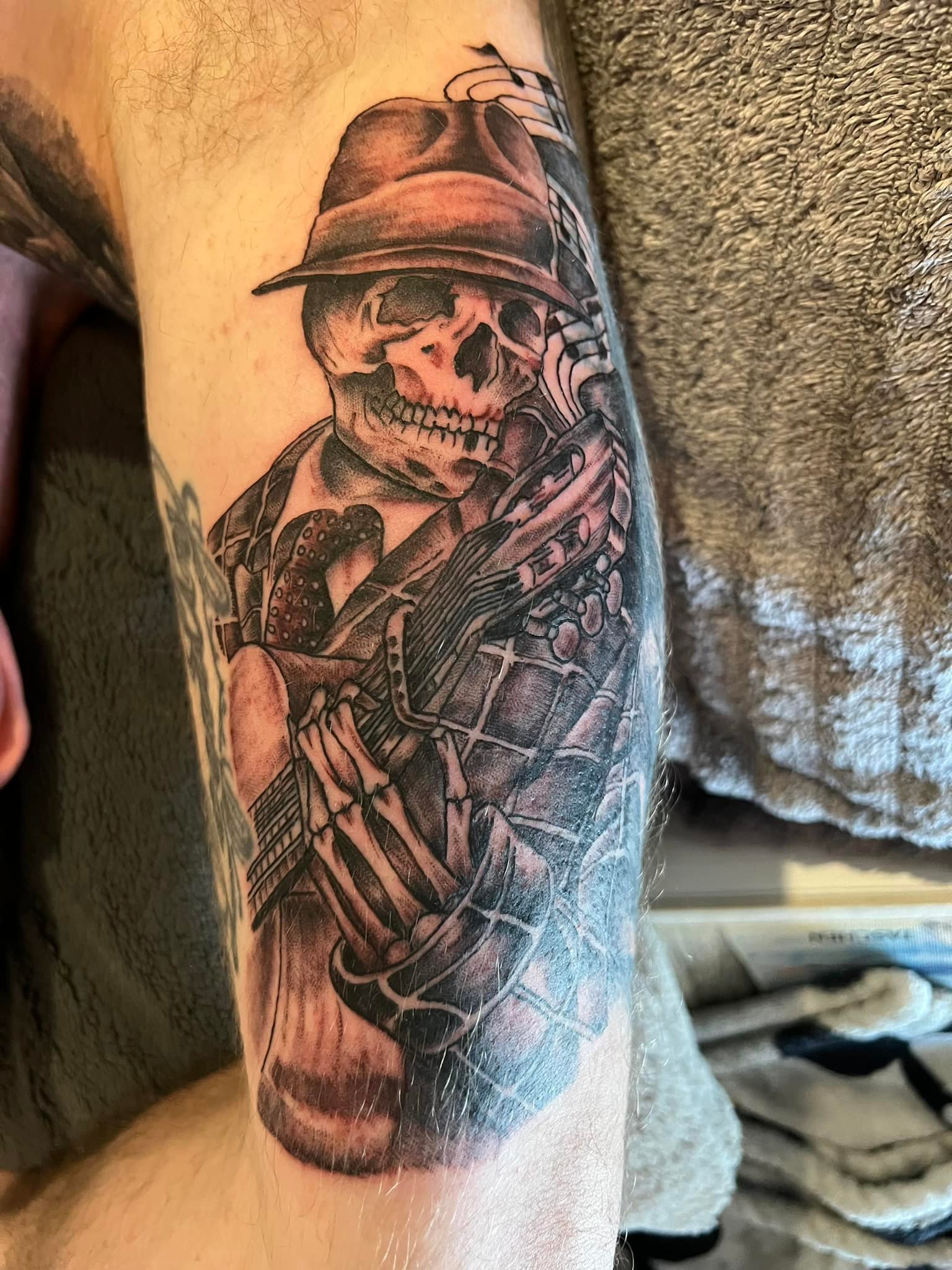 Skeleton playing accordion arm tattoo