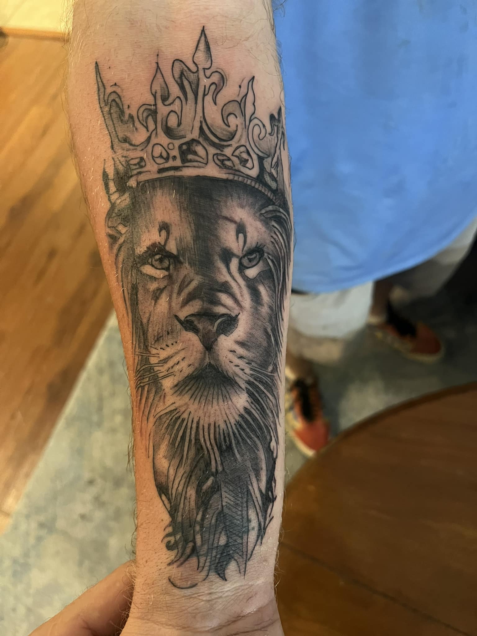 Lion with crown forearm tattoo