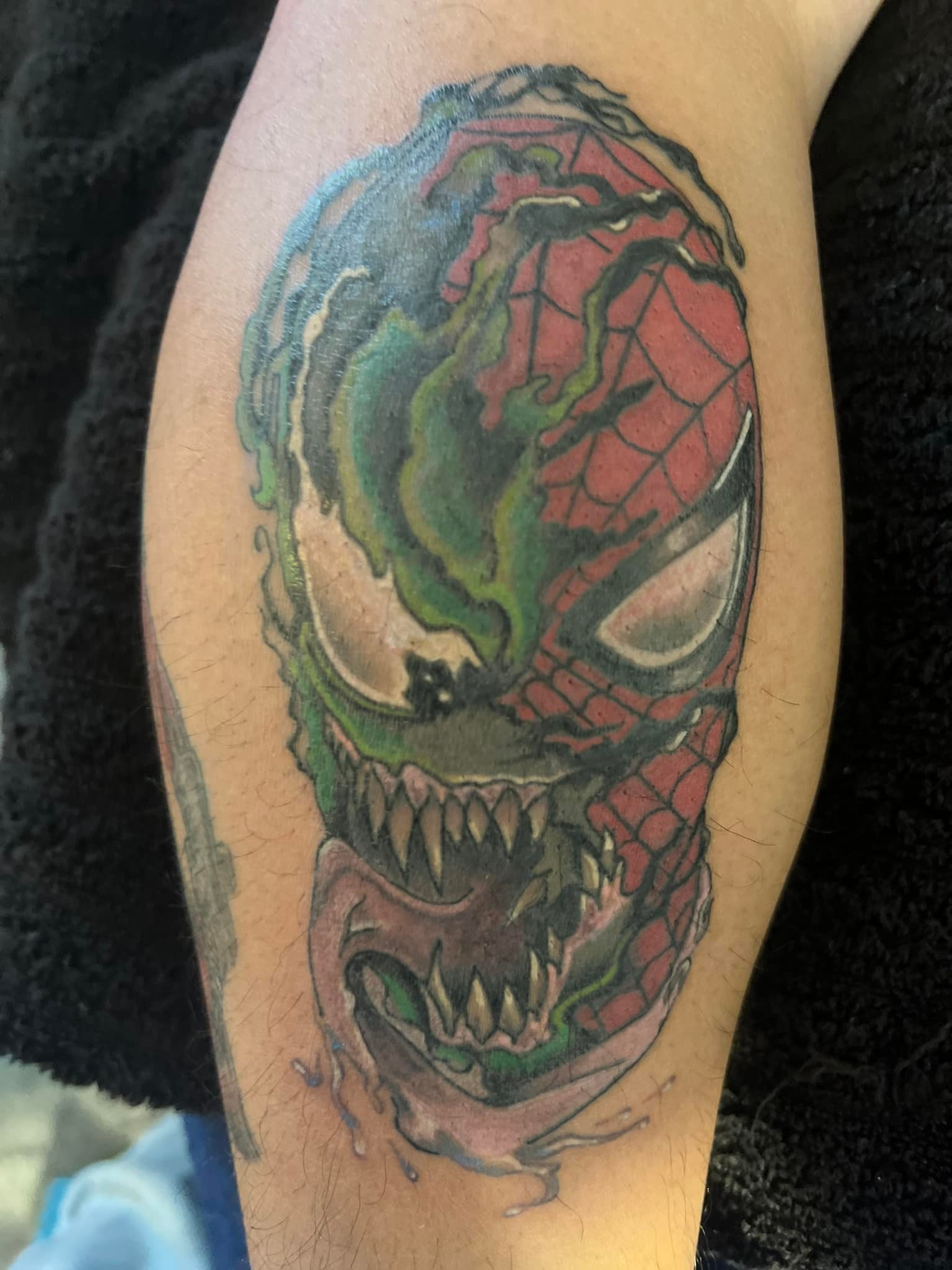 Spider-Man and Venom split face leg tattoo